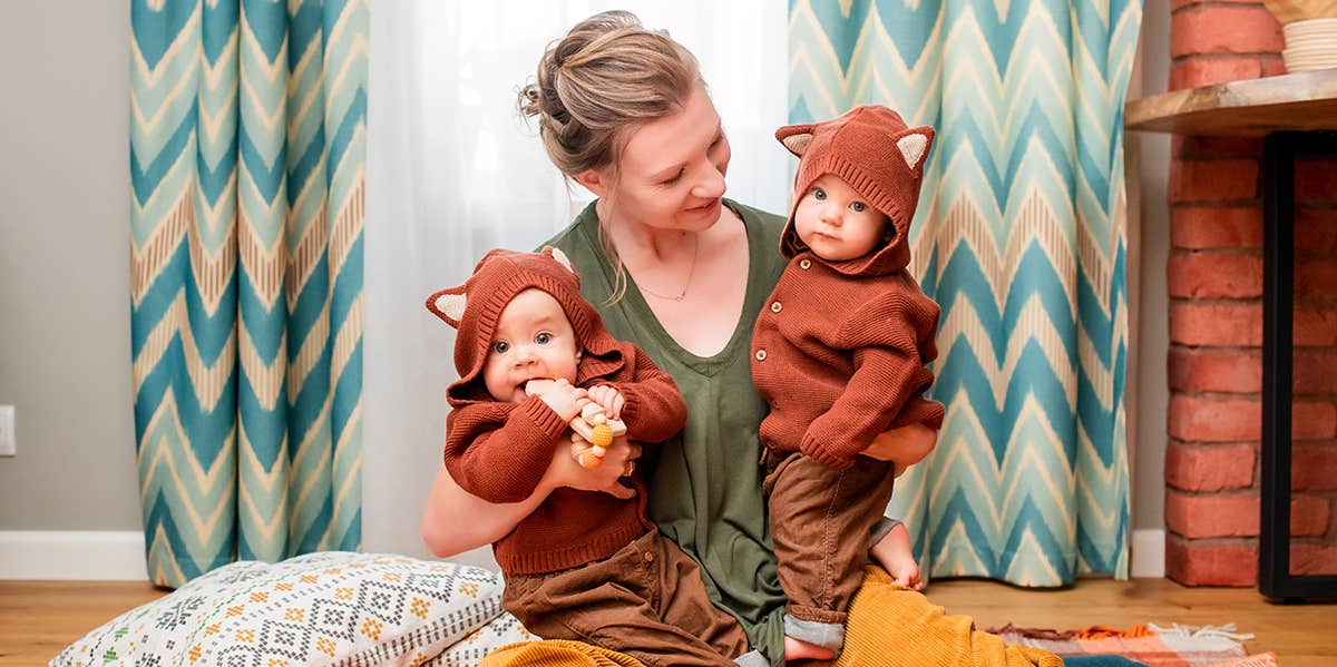 Woman calls co-worker’s name choice idiotic A photograph of a white woman holding two twins in identical animal outfits.