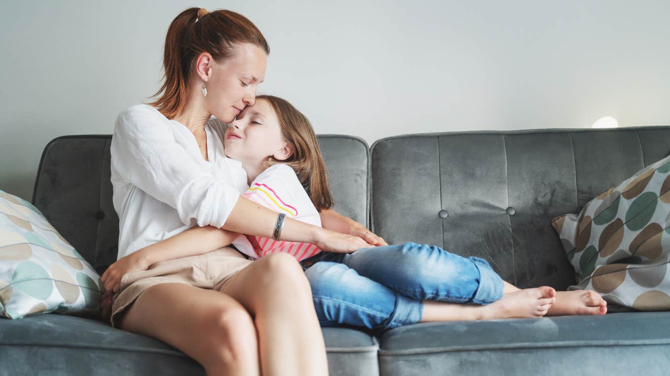 woman hugging young girl on the couch