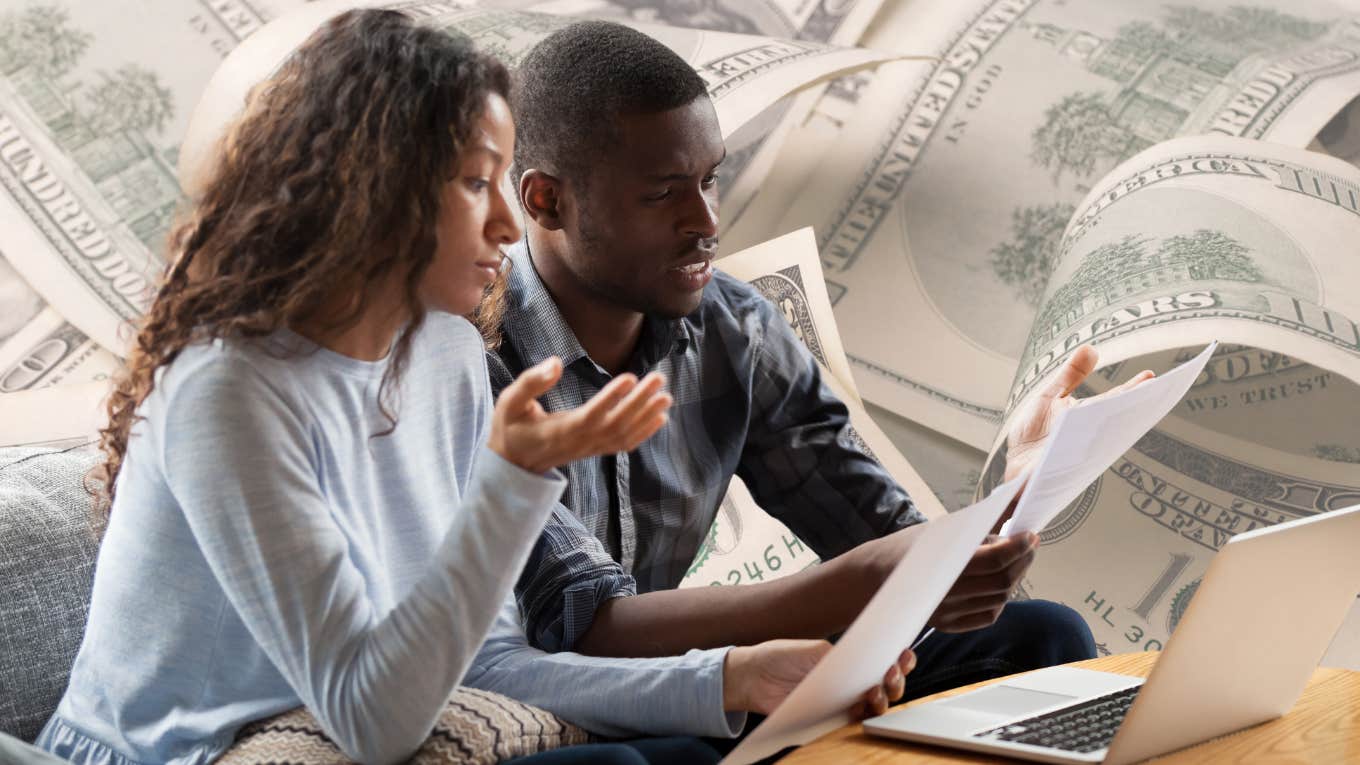 Married couple looking concerned while looking at papers and their laptop. 