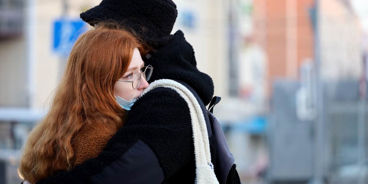 Woman being hugged by partner