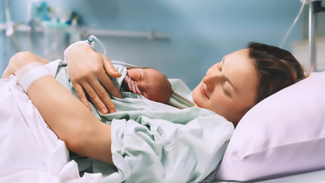 mom hugging her newborn baby after delivery in hospital bed