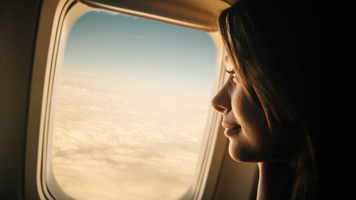 woman looking out airplane window