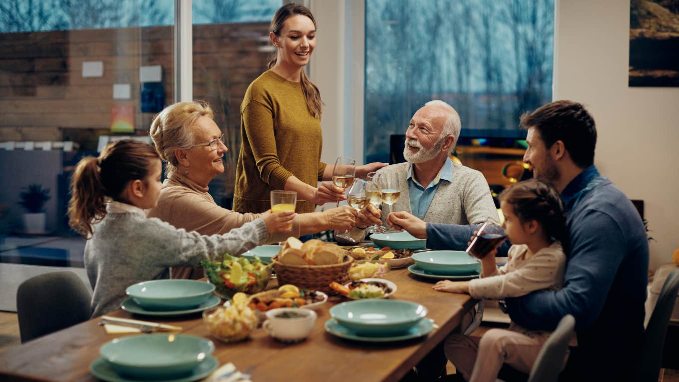 family toasting while having lunch together in dining room.