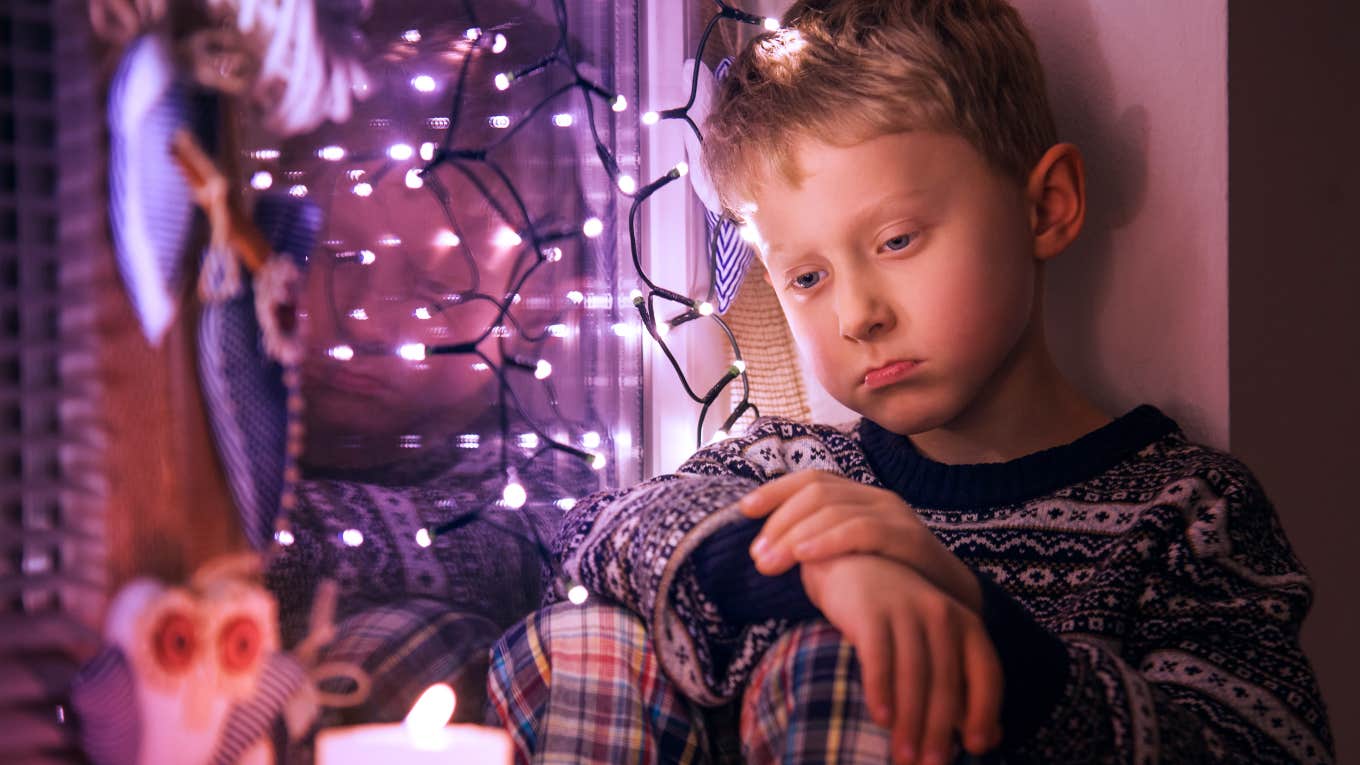 Woman Makes Nephew Cry By Taking His Gift & Giving It To Her Son sad little boy with Christmas decorations