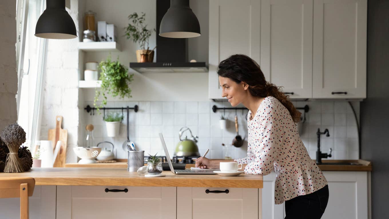 woman smiling at a note in the kitchen