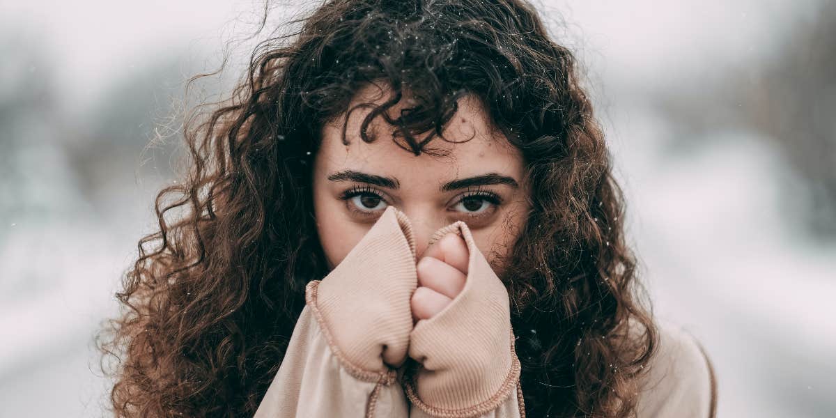 Woman hiding face behind hands