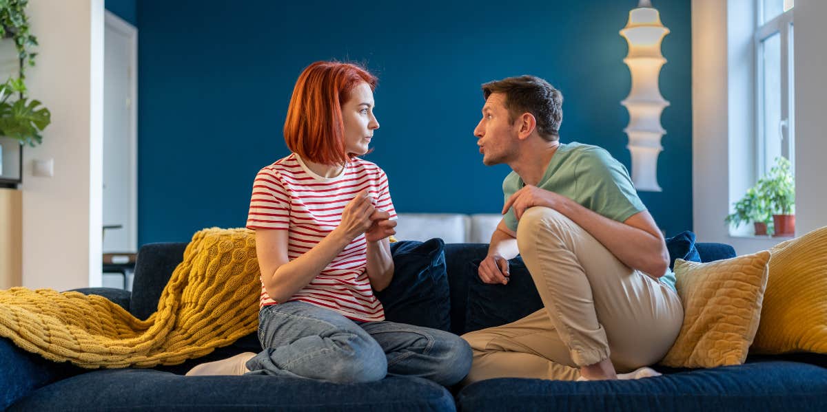 man yelling at woman on the couch