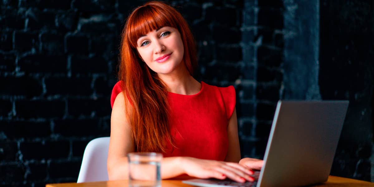 Woman Constantly Makes Baked Goods For Her Married ‘Work Husband’ Despite His Lack Of Interest And Is Almost Reported To HR Woman in an office working on a laptop