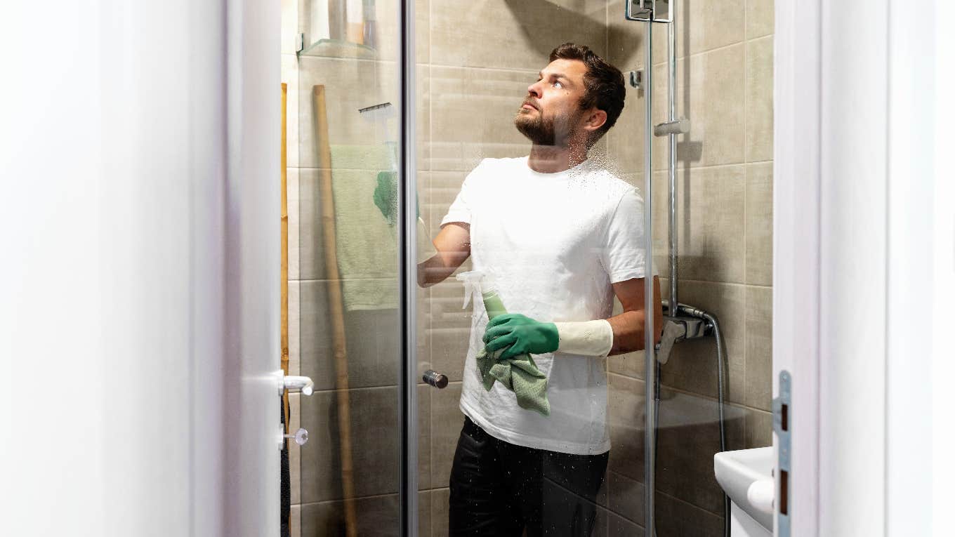 man cleaning shower