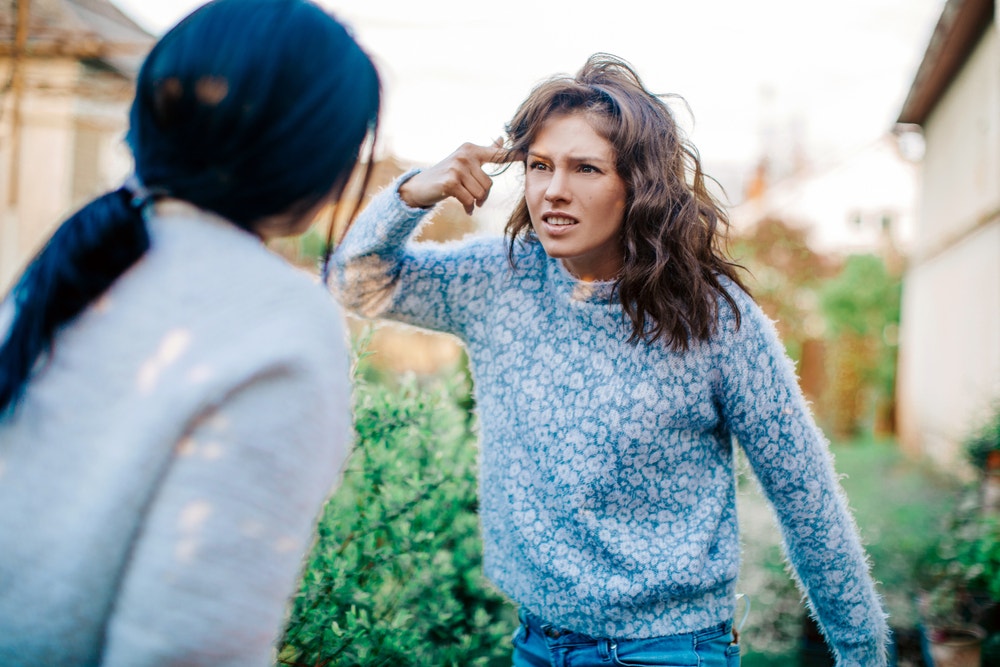 Woman arguing with another woman.