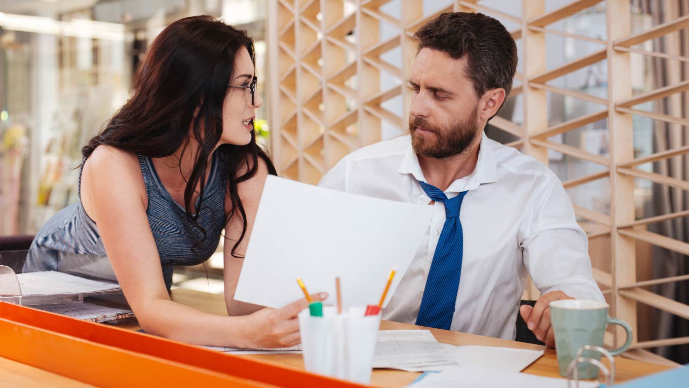 dark-haired woman next to man workplace