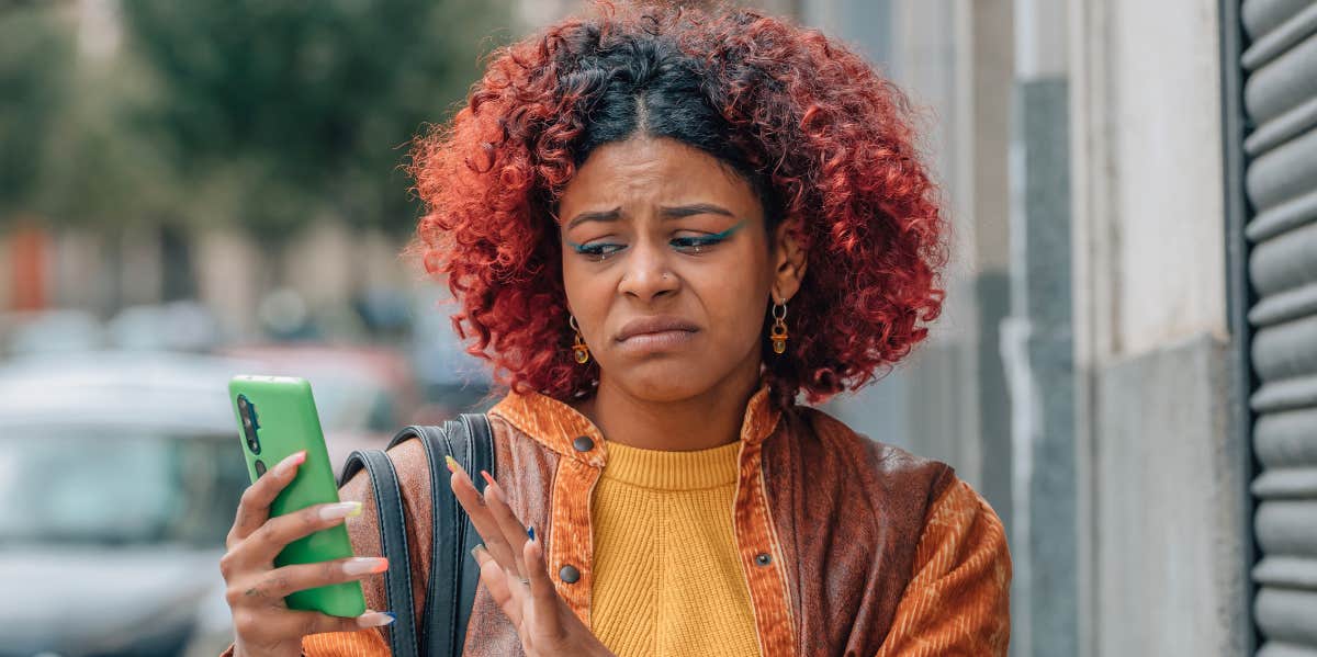 A woman looking disgusted at her phone