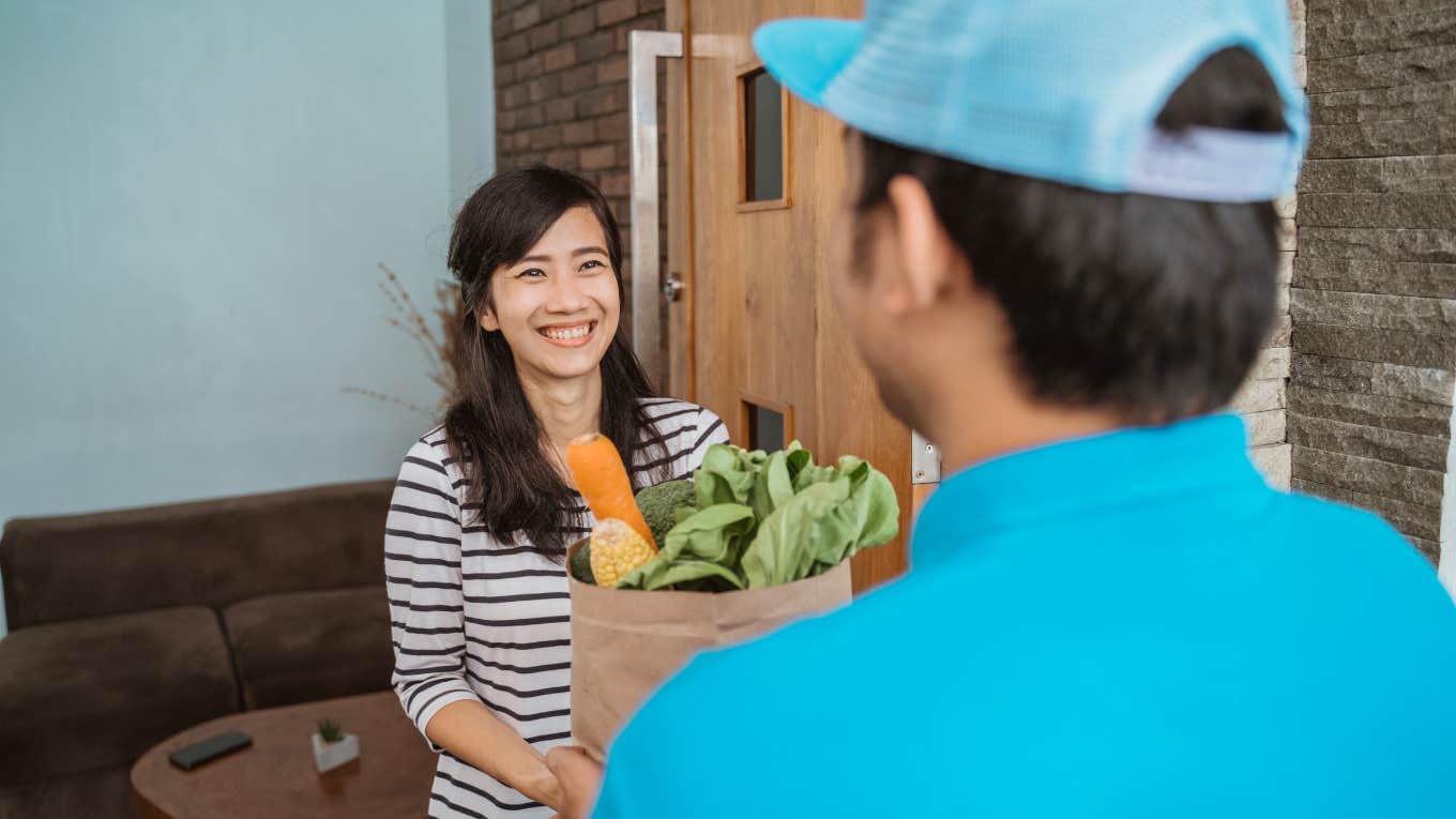 Woman receiving grocery delivery from Uber Eats