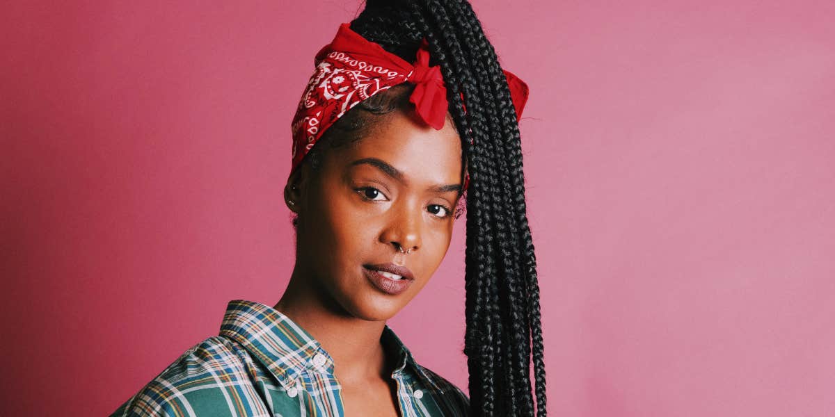 Woman with braids in front of a pink background