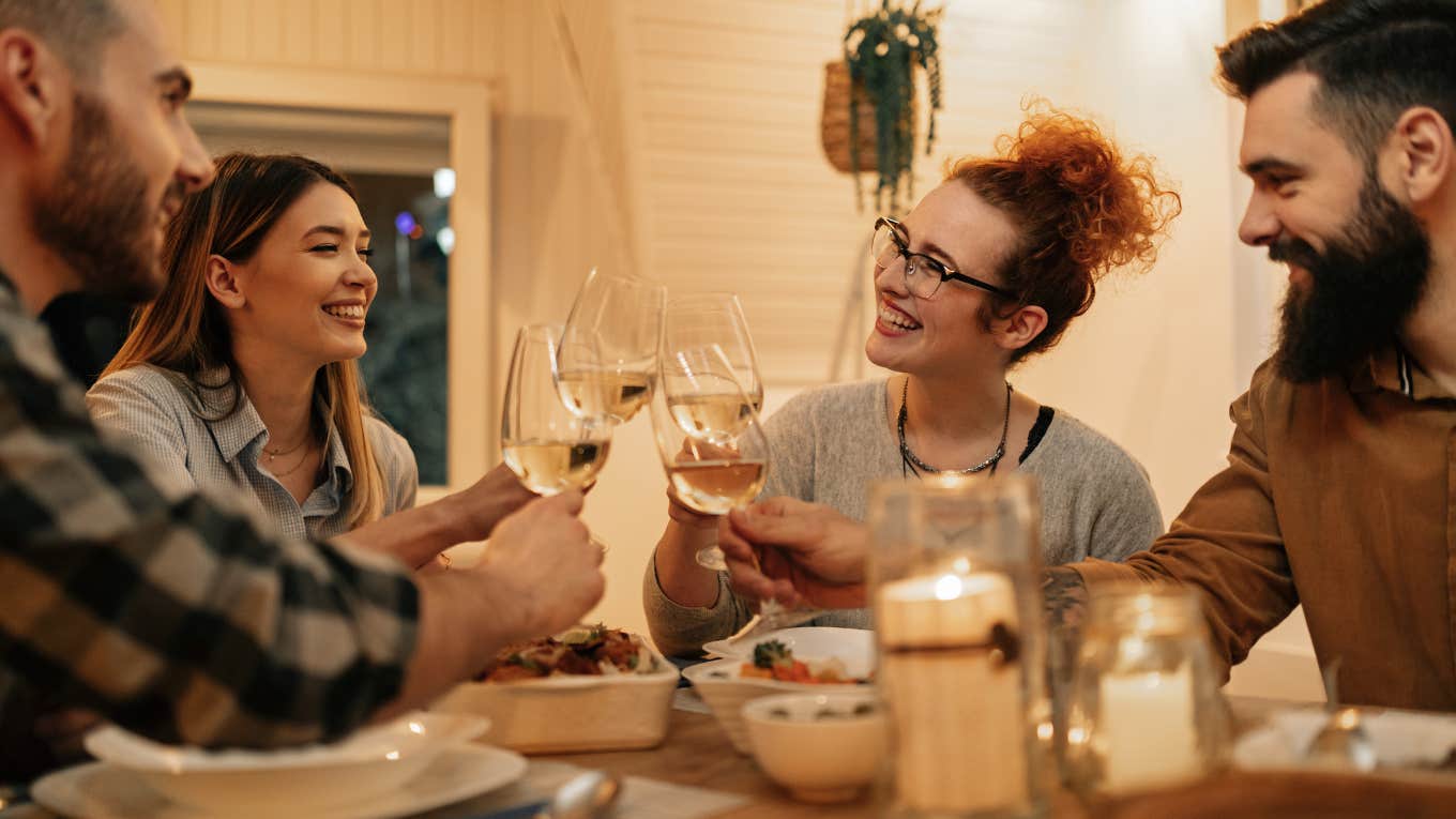 friends having fun while toasting during dinner at home.