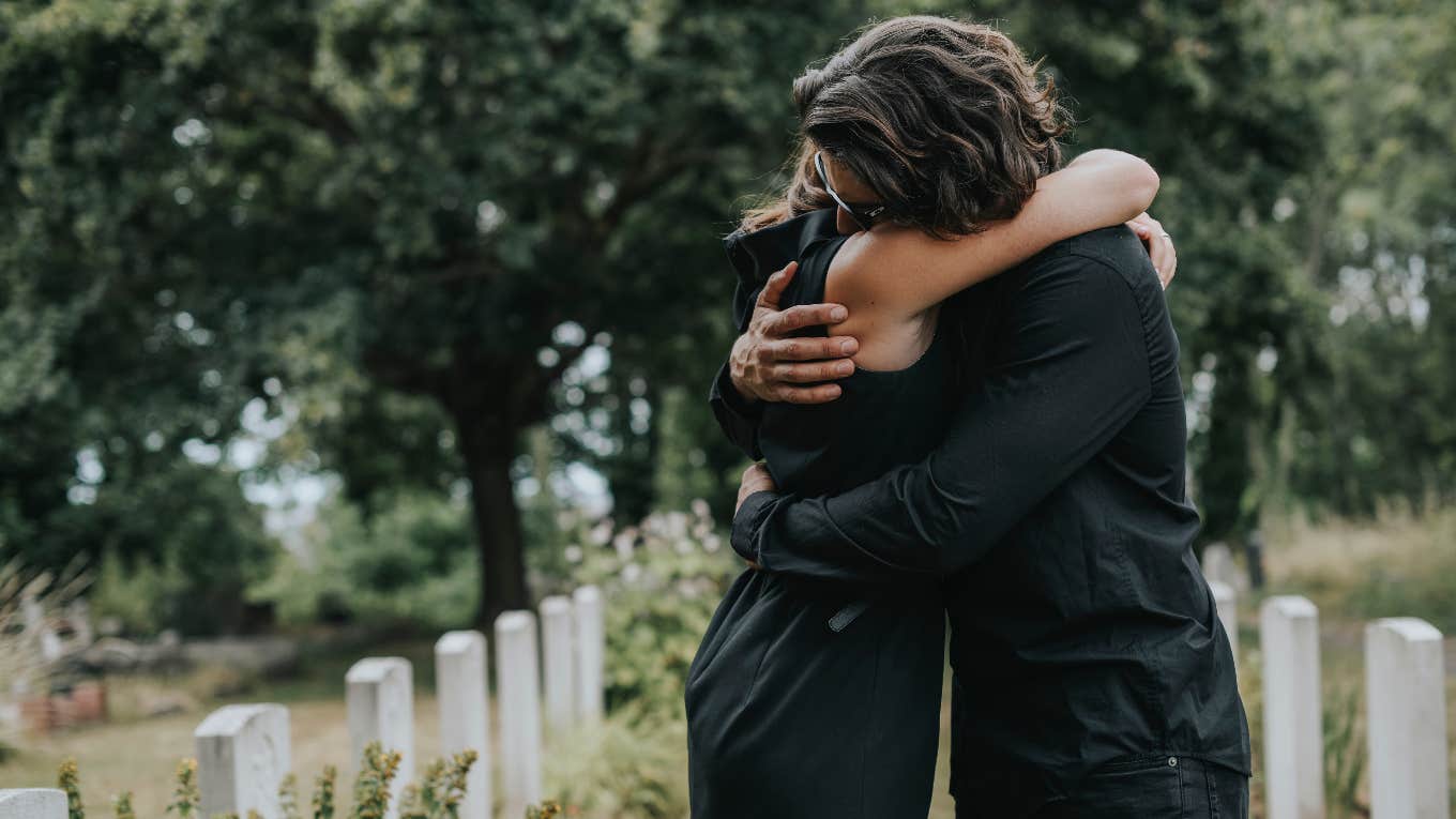 people hugging at cemetary