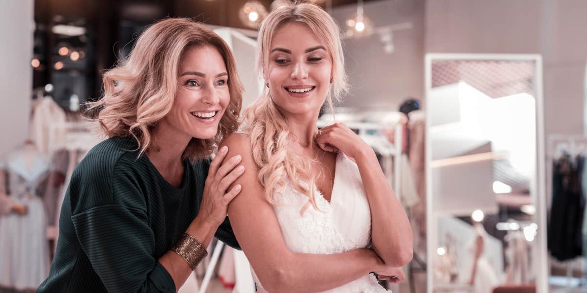 woman and bride shopping at wedding dress boutique