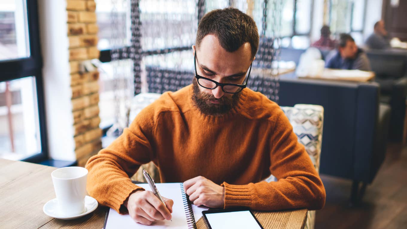 man writing note