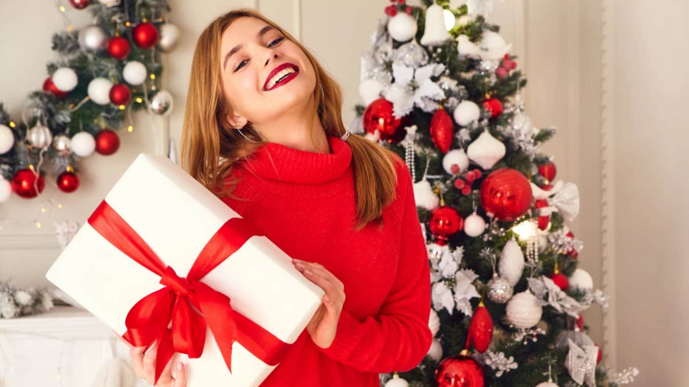 woman in red sweater delighted with Christmas gifts