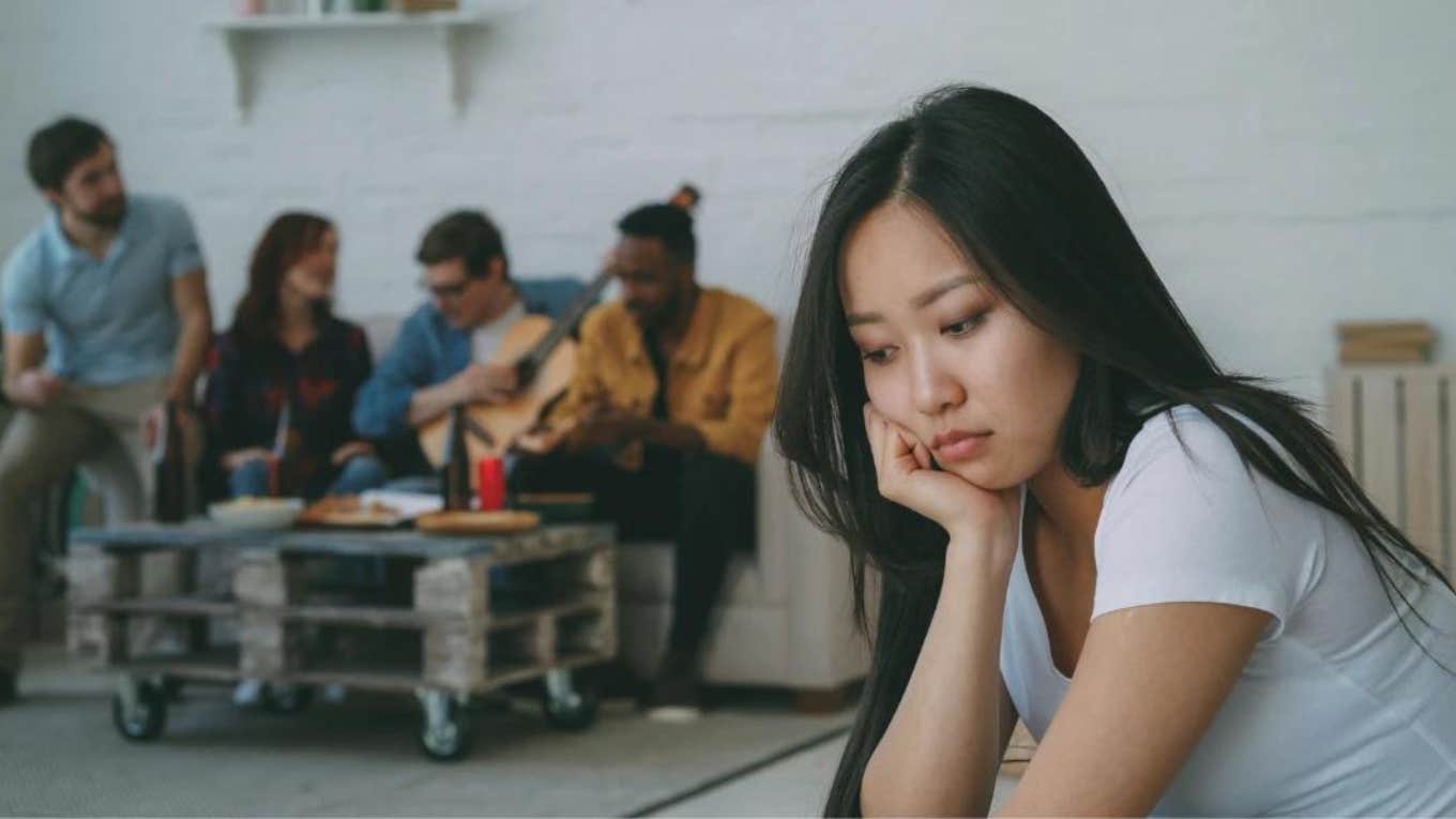 sad woman feeling rejected by group of friends