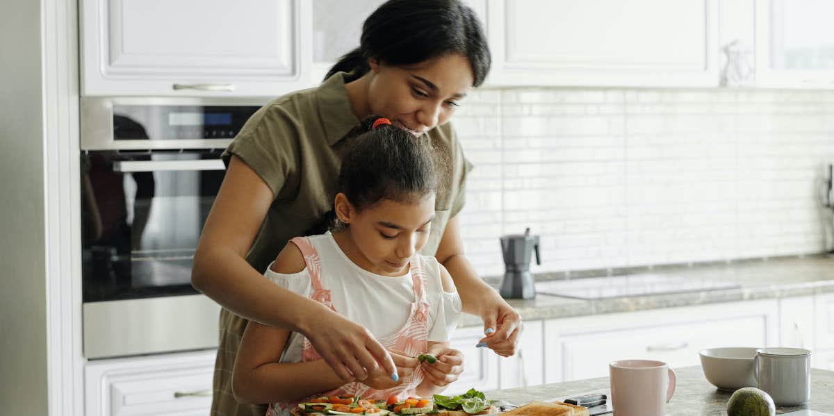 mother and daughter cooking in kitchen