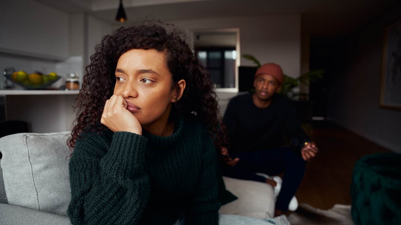 woman ignoring boyfriend while fighting on the sofa in modern apartment