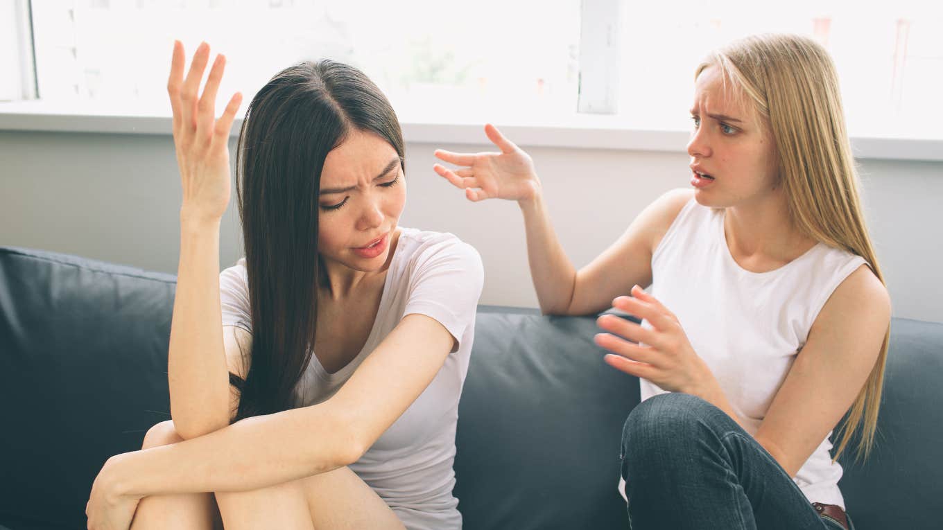 two women having an argument while sitting on a couch