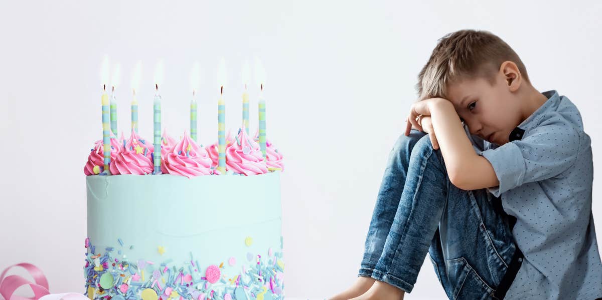 birthday cake with candles, young boy sitting alone