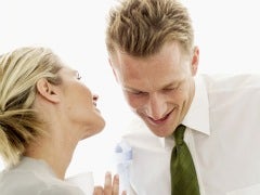 woman whispering in man's ear