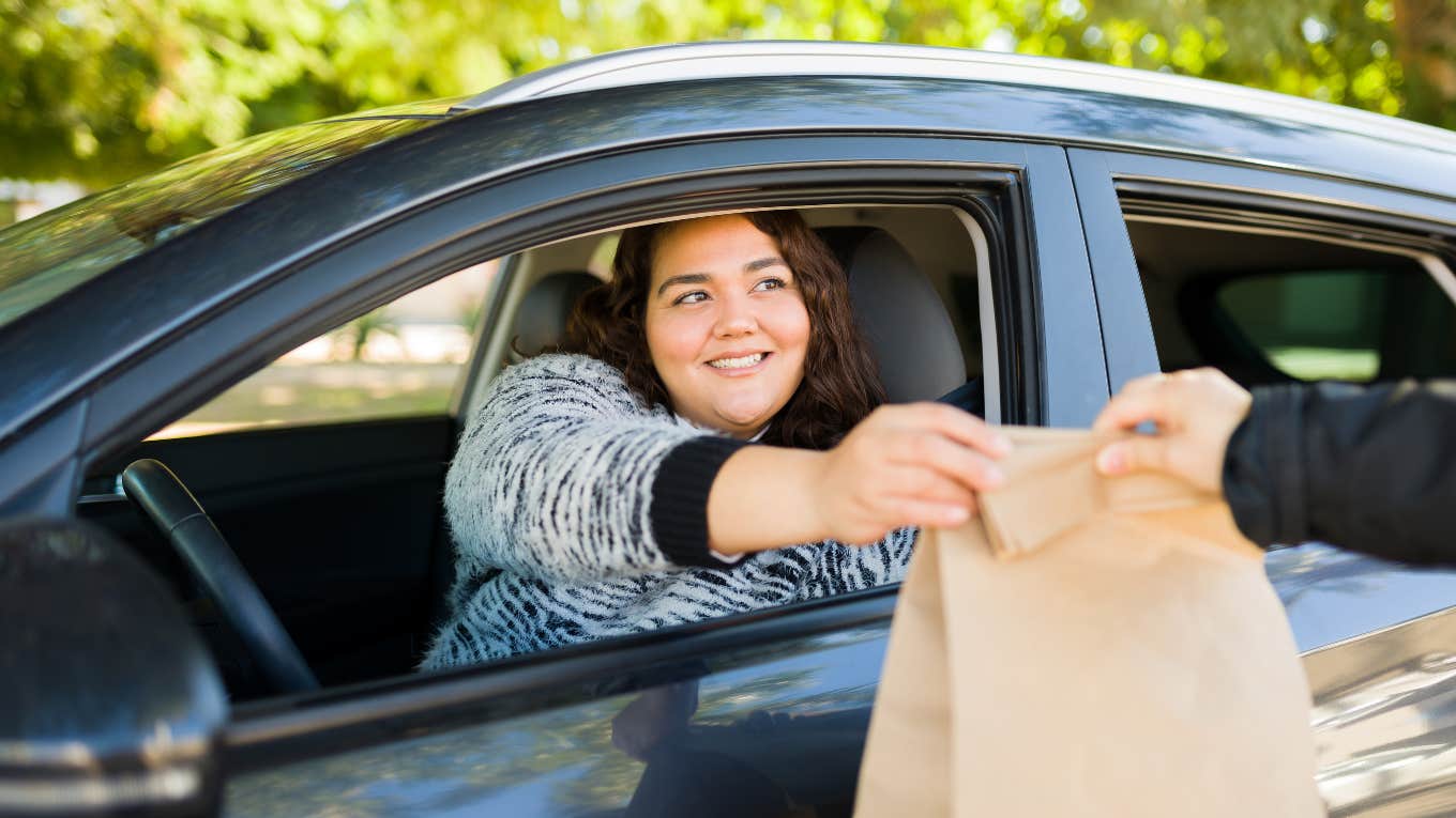 woman picking up food at drive-thru