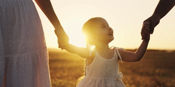 A daughter holds her parents' hands.