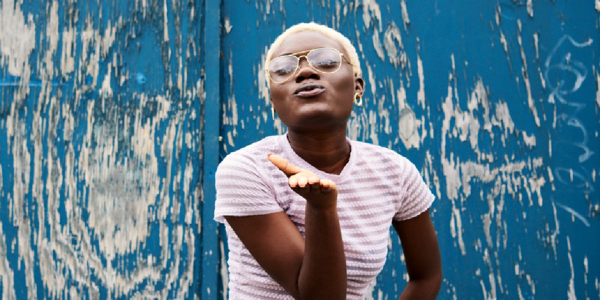 woman with short blonde hair blowing a kiss