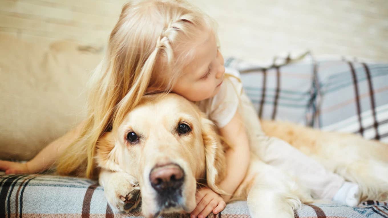 little girl hugging dog