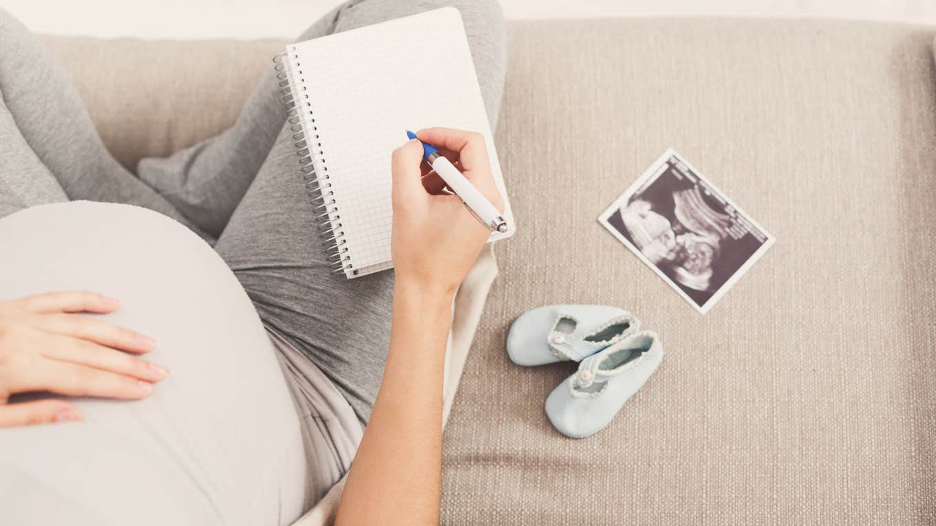 pregnant woman writing down baby names