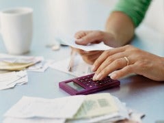 Calculating The Cost Of A Career Change Woman's hand using a calculator