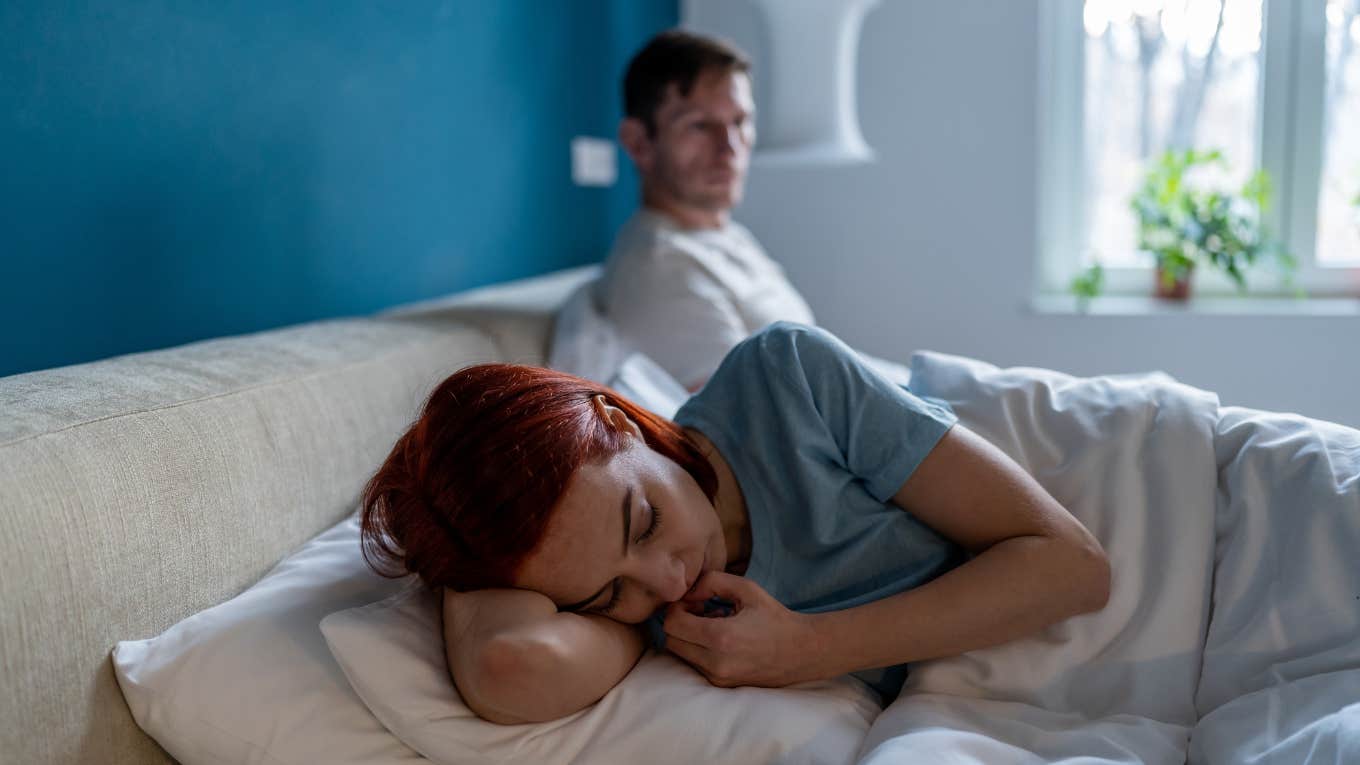 Wife Says Her Husband Is Having Sleepovers At His Ex-Girlfriend's House But Claims They're Just Friends woman lies on edge of bed separated from husband after argument