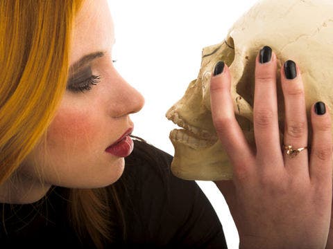 woman kissing skull