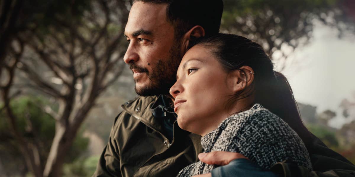 couple in the woods, woman looks serious