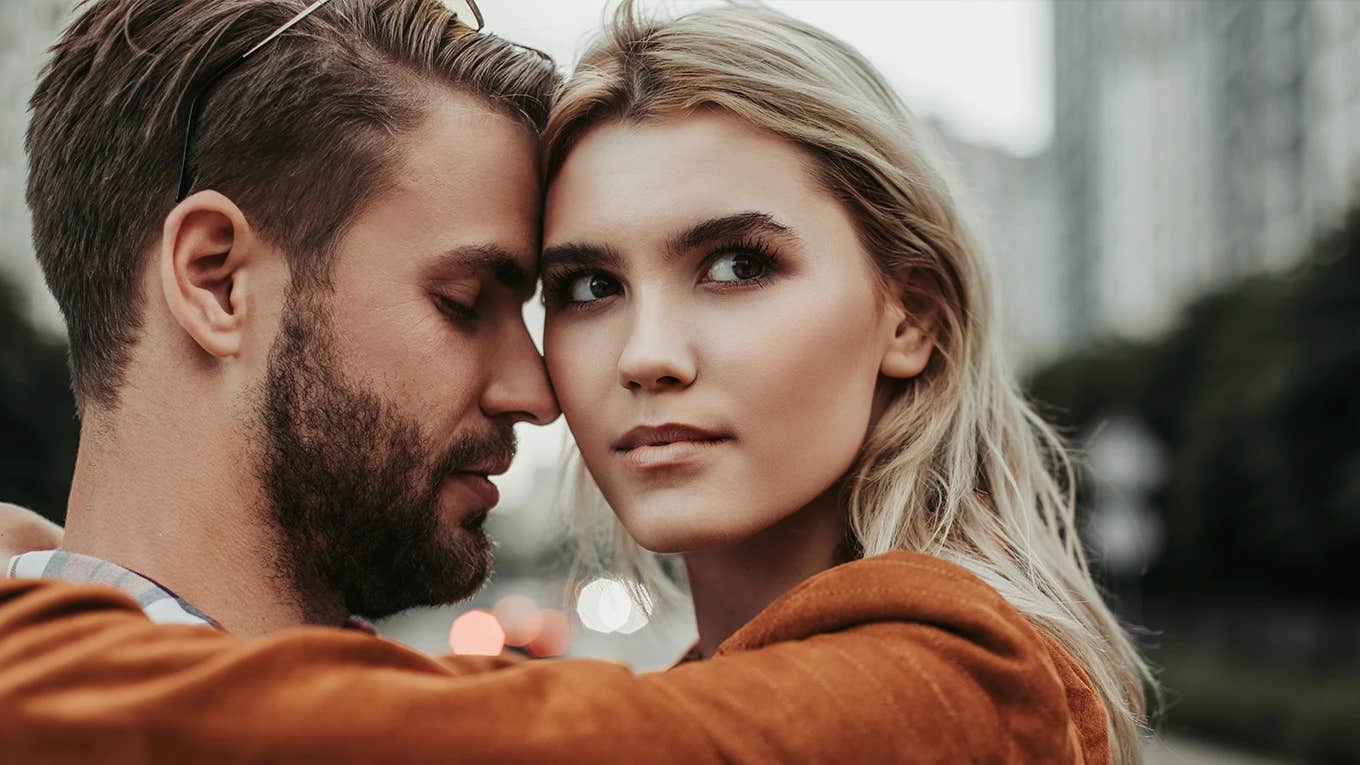 woman looking at camera hugging man