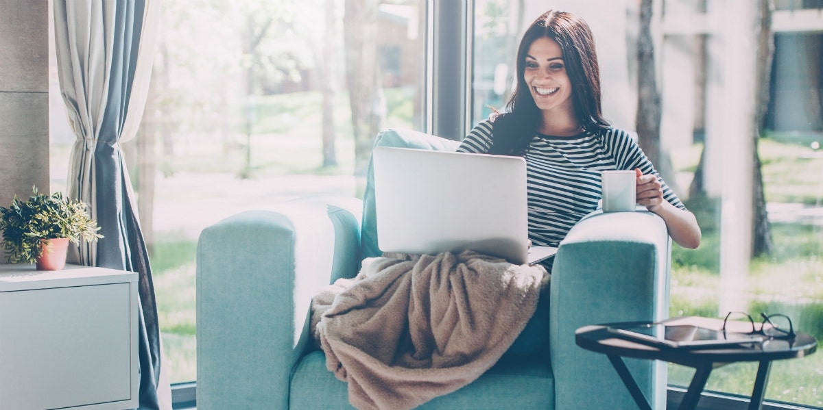 happy woman at home with laptop