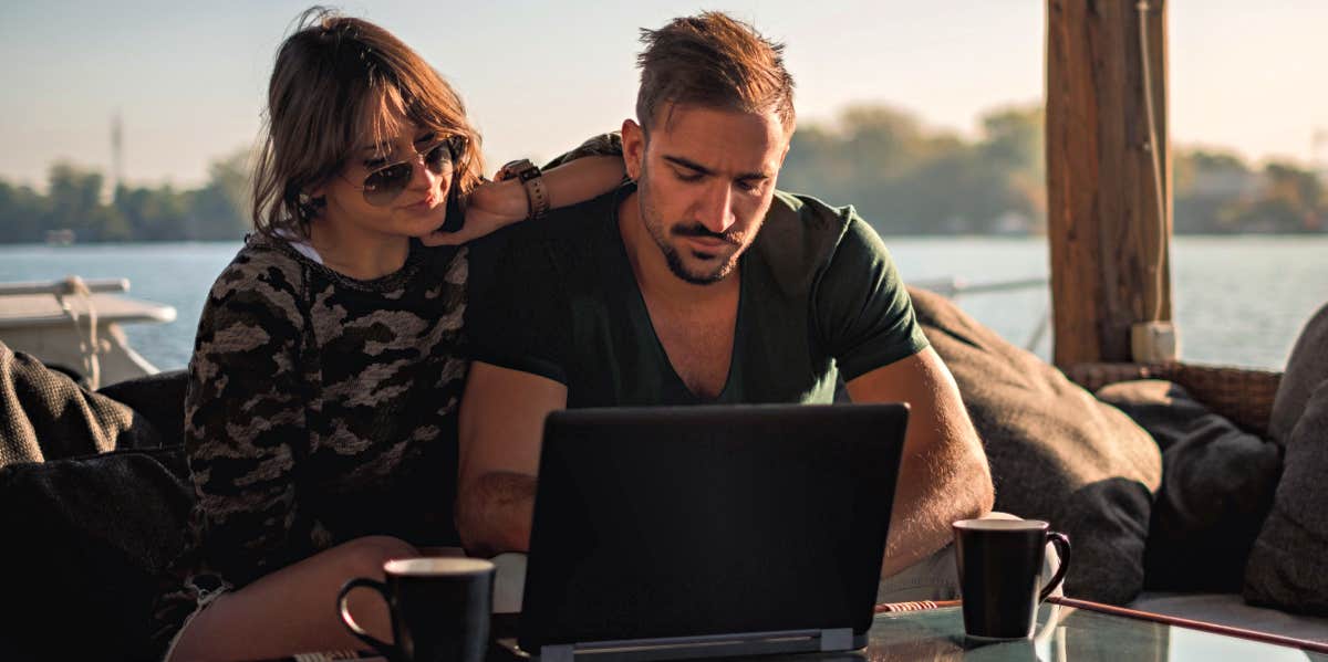 A Work Vacation With My Husband Made Me Rethink Our Entire Marriage man and woman working on laptop while on vacation