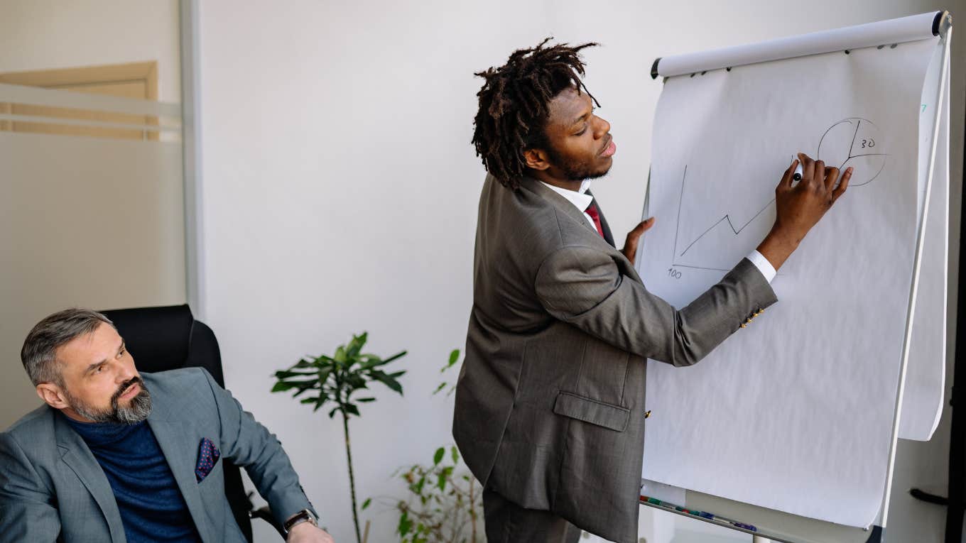 employee writing on chart at meeting