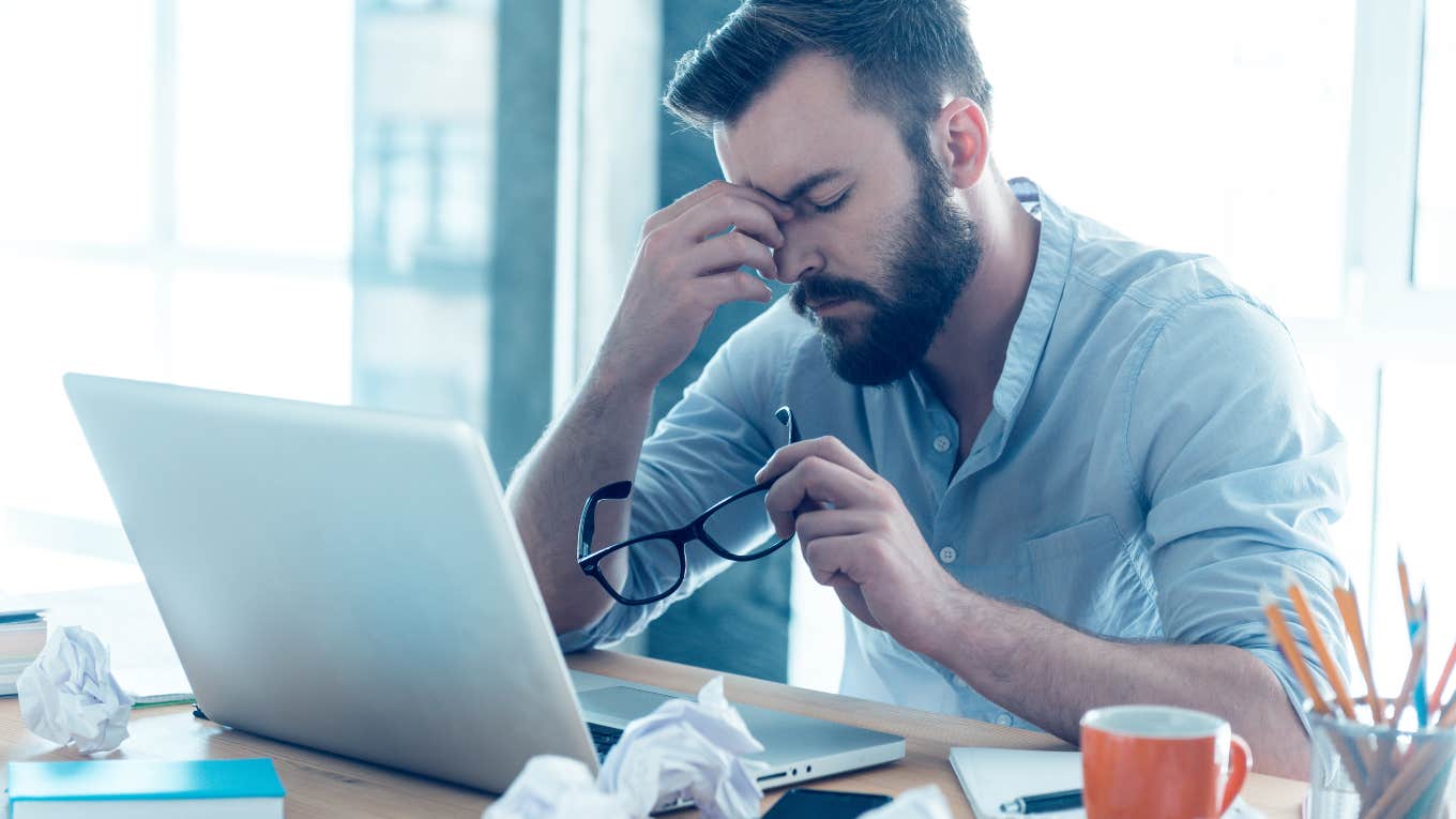 man sitting at computer frustrated at work