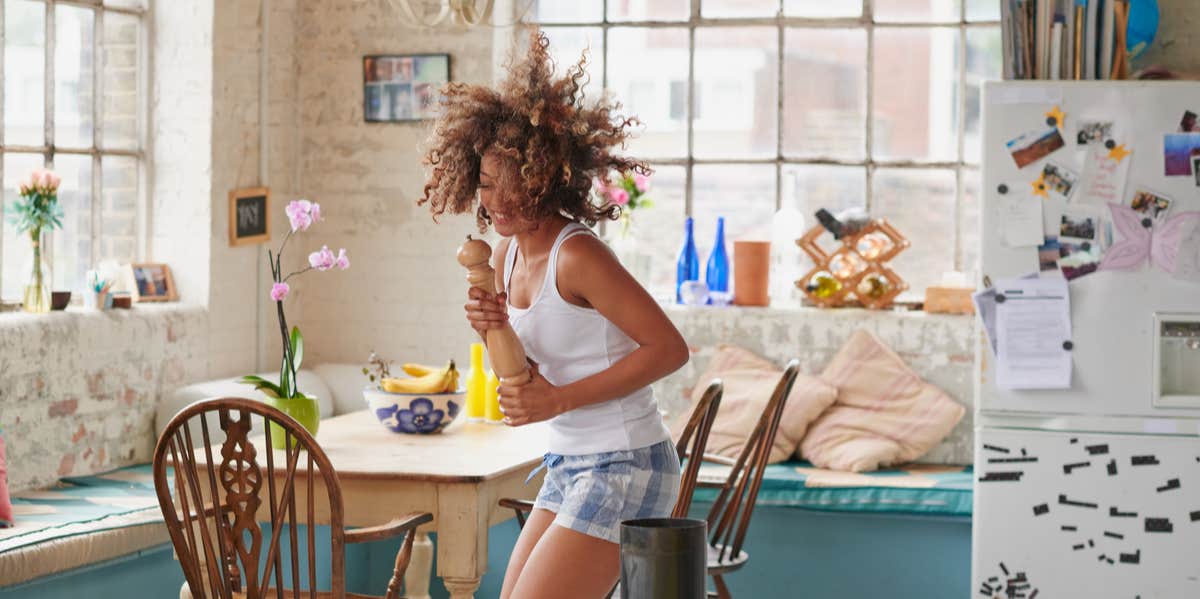 woman dancing in a kitchen in her pajamas