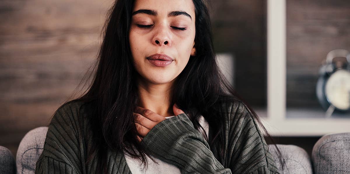 devastated woman holding hand over her heart