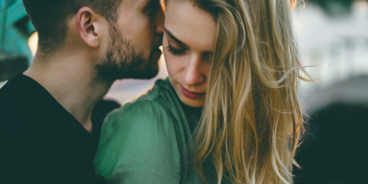 man whispering in woman's ear 