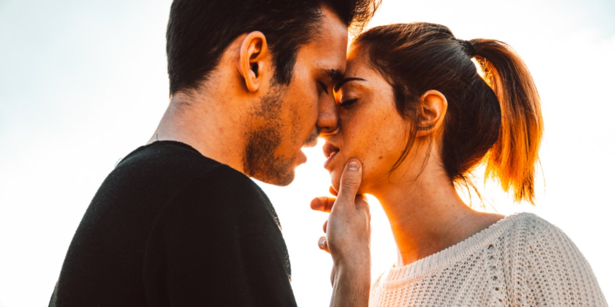 man grabbing woman's face to kiss