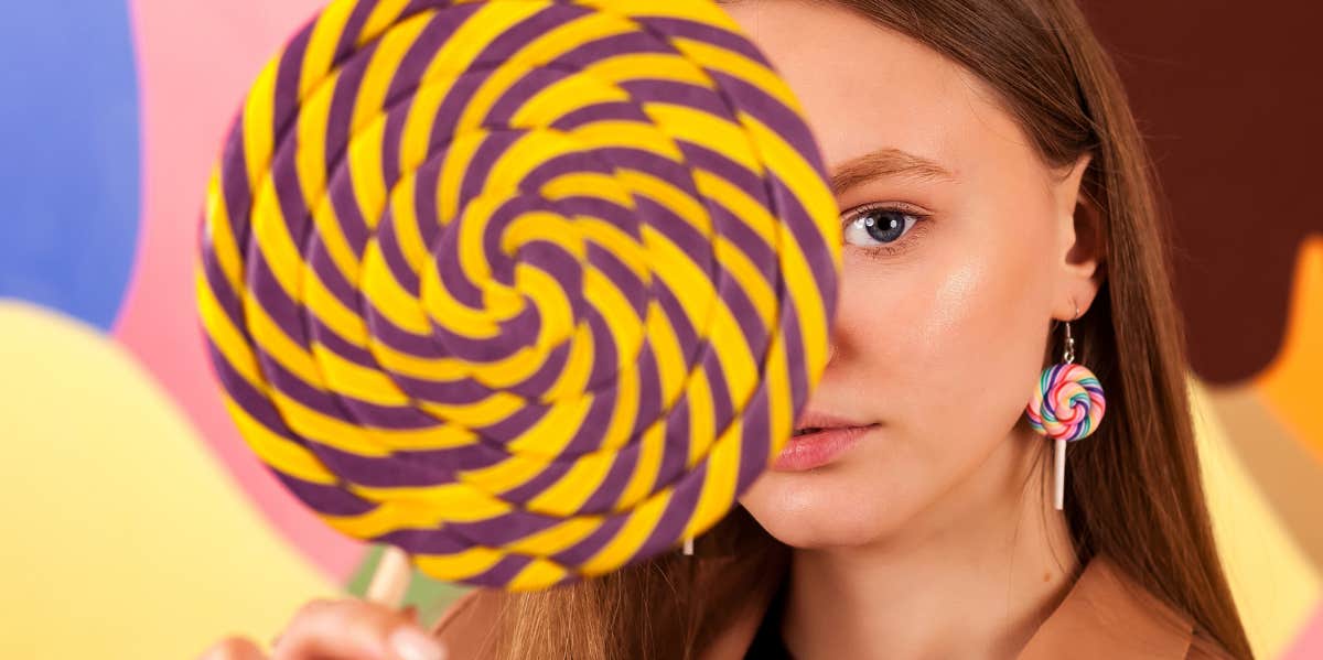 woman with lollipop in front of face