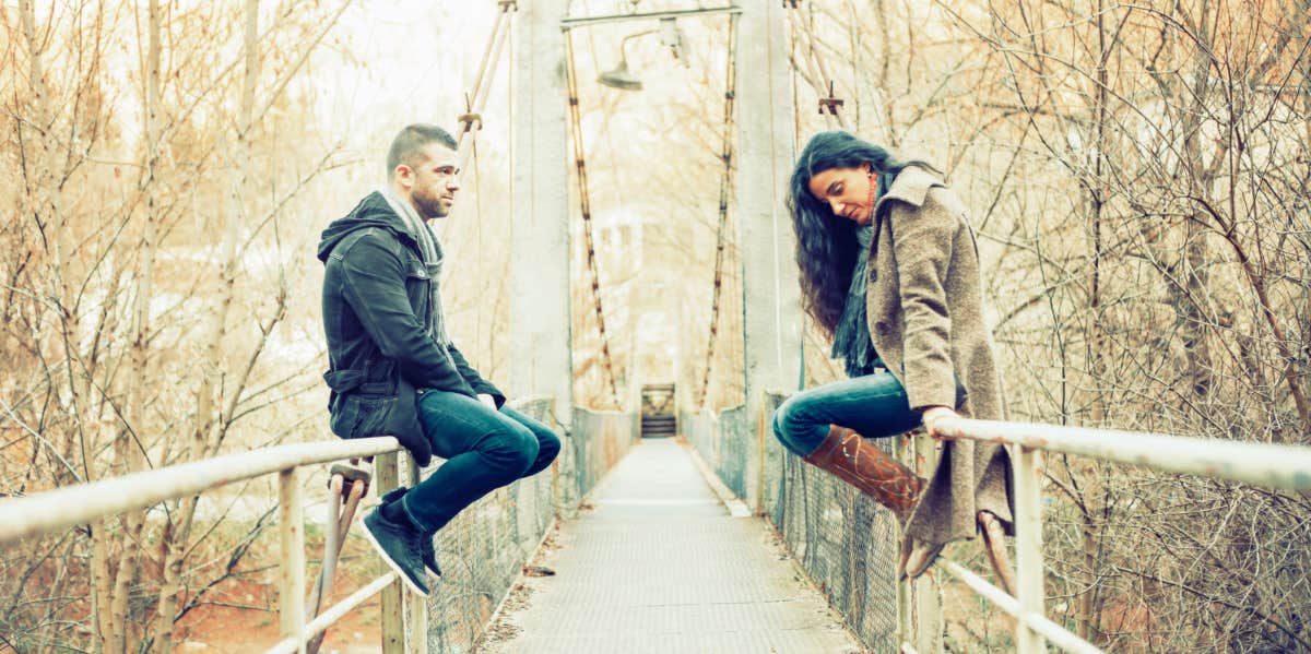 couple sitting on bridge