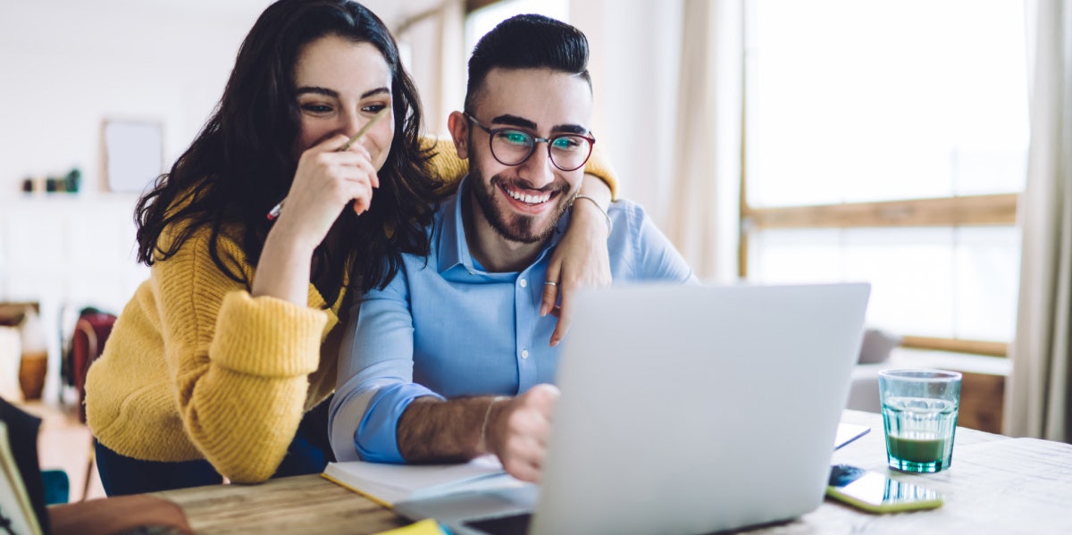 couple laughing staring at computer screen